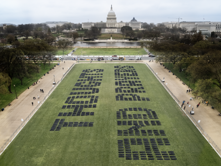 Body bags spell out "thought and prayers" on the National Mall.