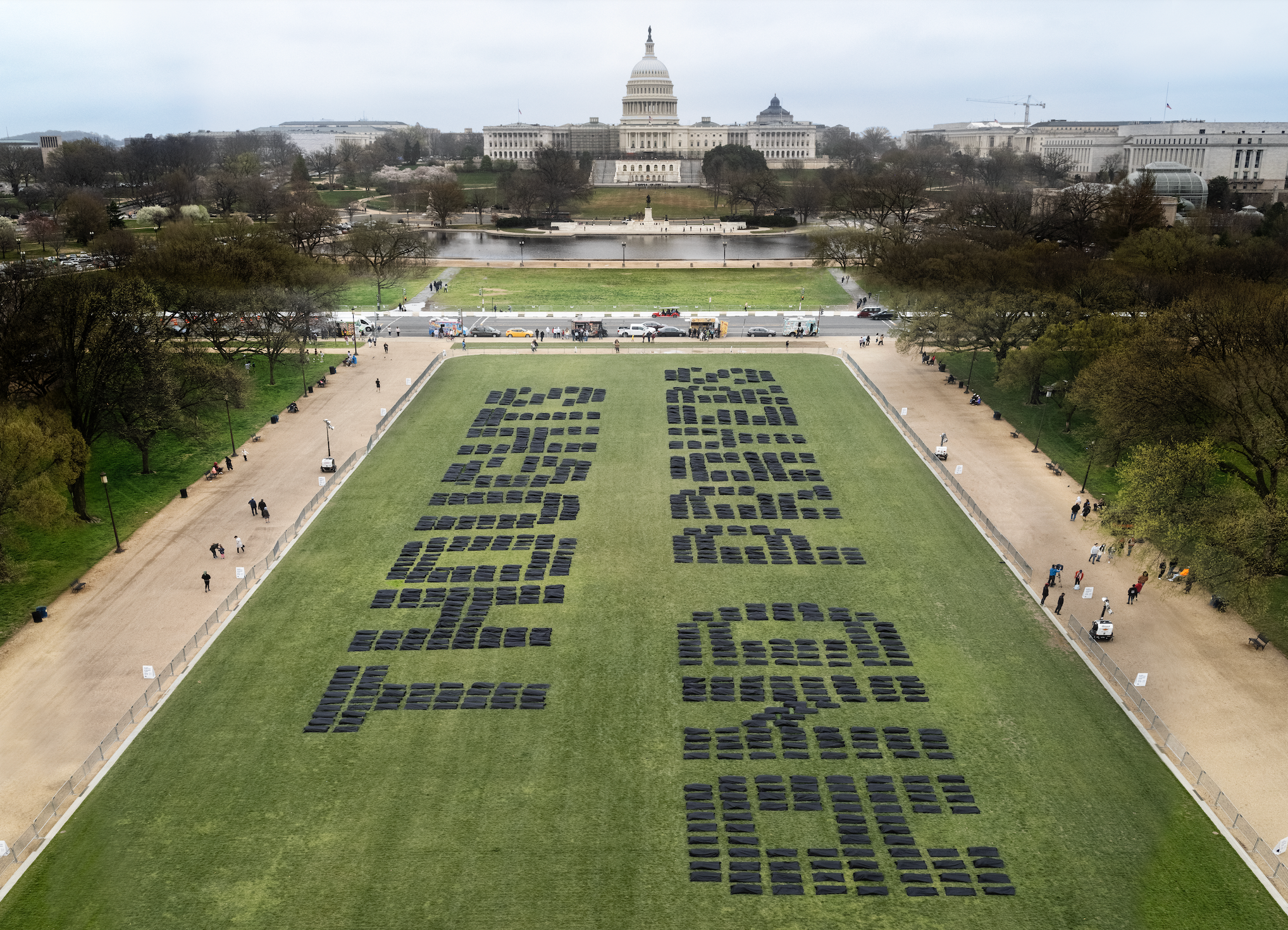 Body bags spell out "thought and prayers" on the National Mall.