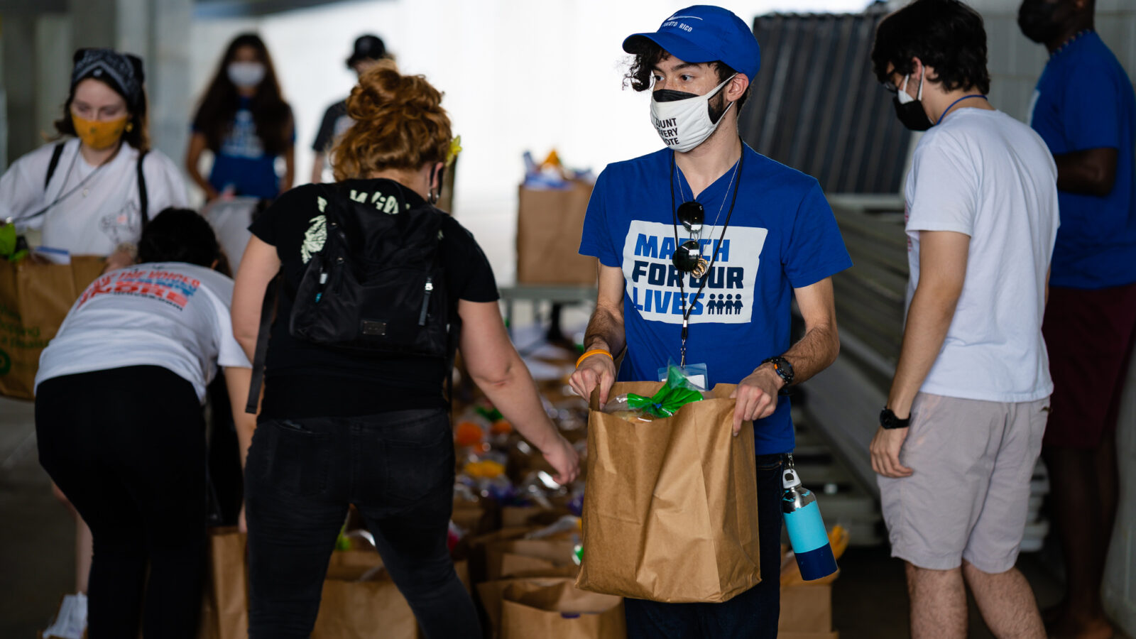 MFOL member carries bag of groceries at a mutual aid drive.